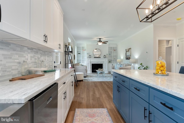 kitchen with dishwasher, white cabinets, hanging light fixtures, and a premium fireplace