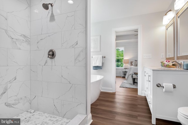 bathroom with vanity, hardwood / wood-style floors, toilet, and tiled shower