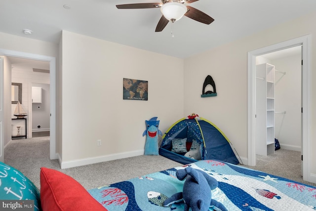 carpeted bedroom featuring ceiling fan, a spacious closet, and a closet