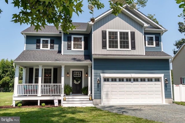 view of front of house with a garage, a front yard, and covered porch