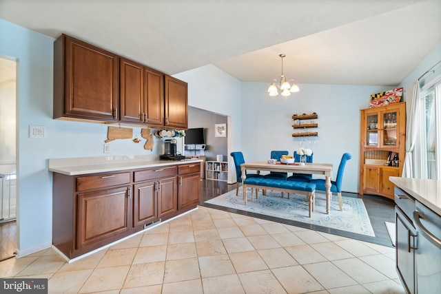 kitchen with a notable chandelier, light tile patterned flooring, hanging light fixtures, and vaulted ceiling