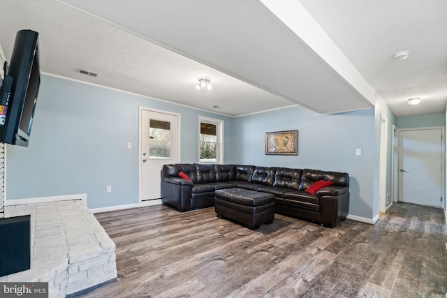 living room featuring crown molding, hardwood / wood-style floors, and a textured ceiling