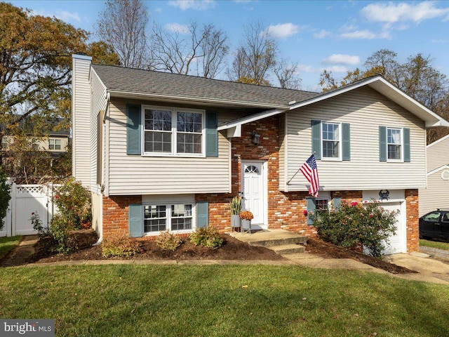 raised ranch featuring a front lawn and a garage