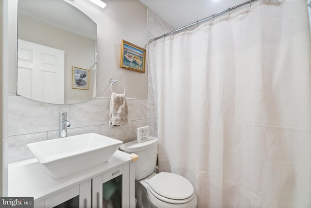 bathroom with backsplash, vanity, tile walls, and toilet