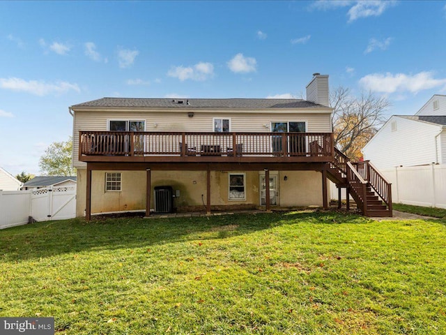 rear view of property with a lawn, a deck, and central AC