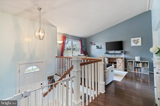 interior space featuring hardwood / wood-style floors, a healthy amount of sunlight, vaulted ceiling, and an inviting chandelier