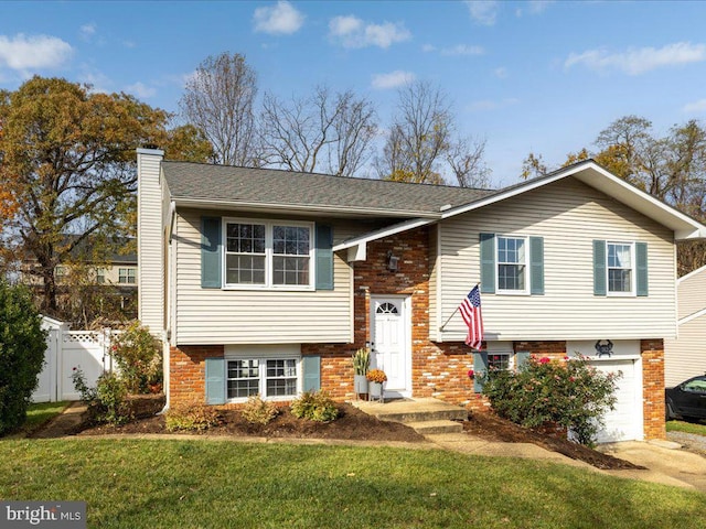 split foyer home with a front yard and a garage