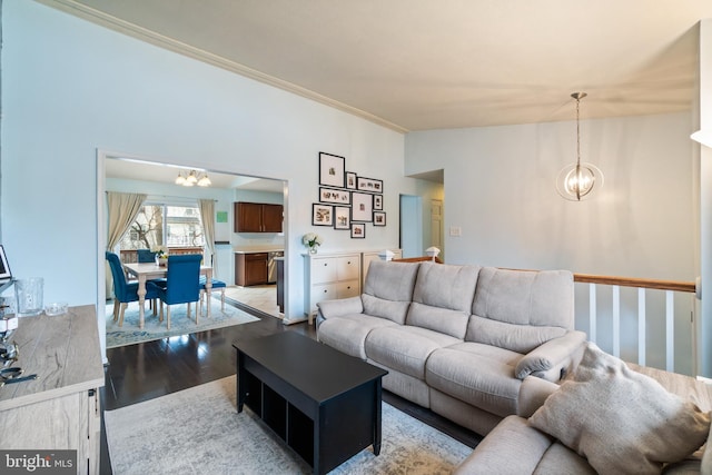 living room featuring light wood-type flooring, vaulted ceiling, an inviting chandelier, and crown molding