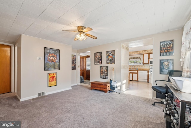 carpeted home office with ceiling fan and sink