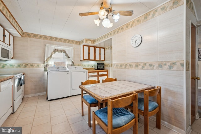 interior space with white appliances, ceiling fan, light tile patterned floors, independent washer and dryer, and tile counters