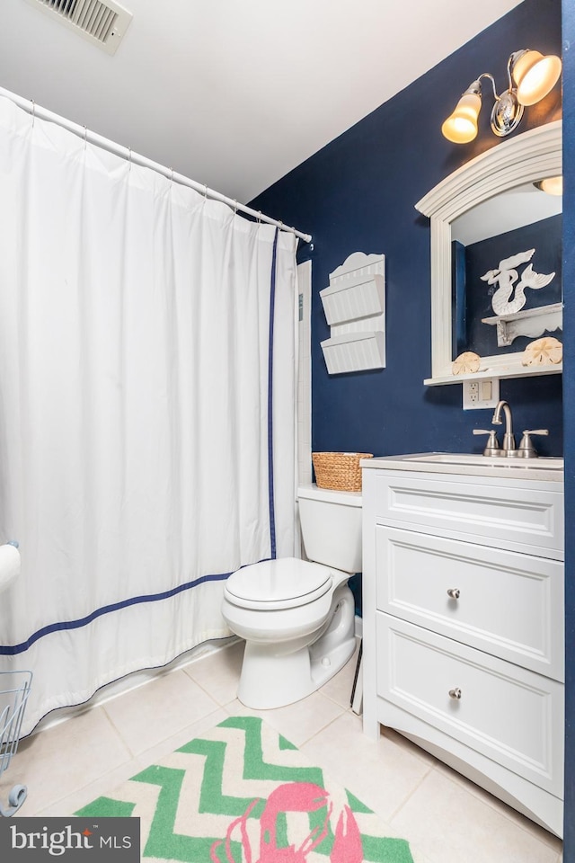 bathroom with toilet, tile patterned flooring, and vanity