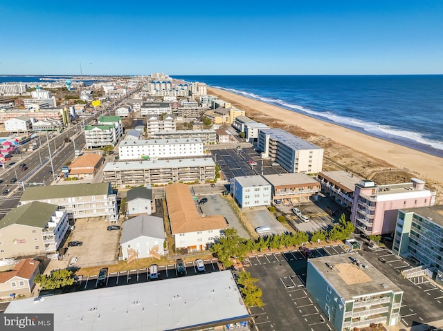 birds eye view of property featuring a water view and a beach view