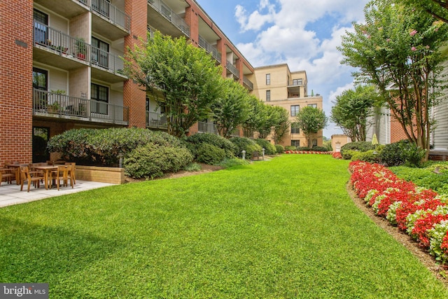 surrounding community with a lawn and a patio