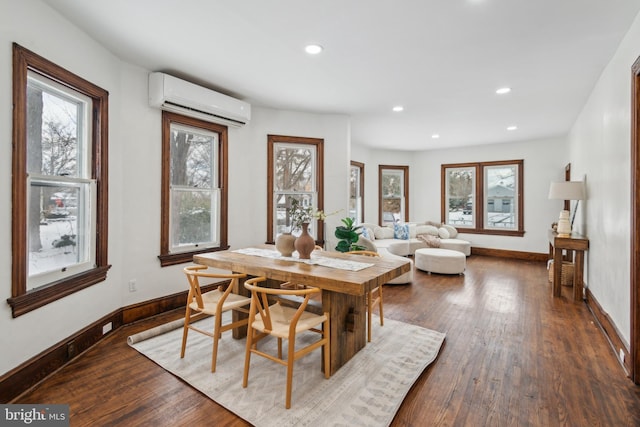 dining space featuring a wall unit AC and dark hardwood / wood-style flooring