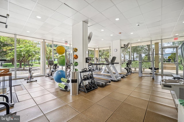 gym with a paneled ceiling, plenty of natural light, and floor to ceiling windows