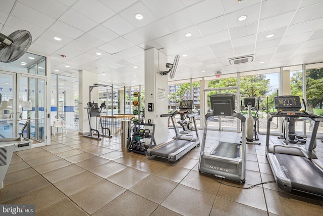 gym featuring a drop ceiling and floor to ceiling windows