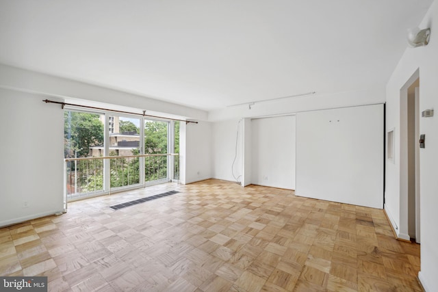 empty room featuring track lighting and light parquet floors