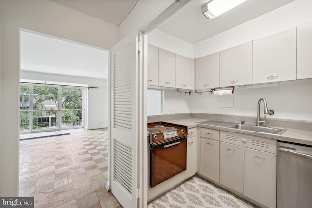 kitchen featuring stainless steel dishwasher, white cabinets, electric stove, and sink