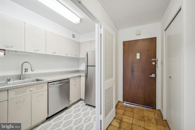 kitchen with white cabinets, stainless steel appliances, and sink