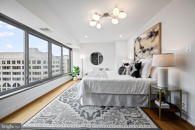 bedroom with a chandelier and hardwood / wood-style flooring