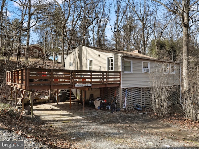 rear view of house featuring a wooden deck and cooling unit