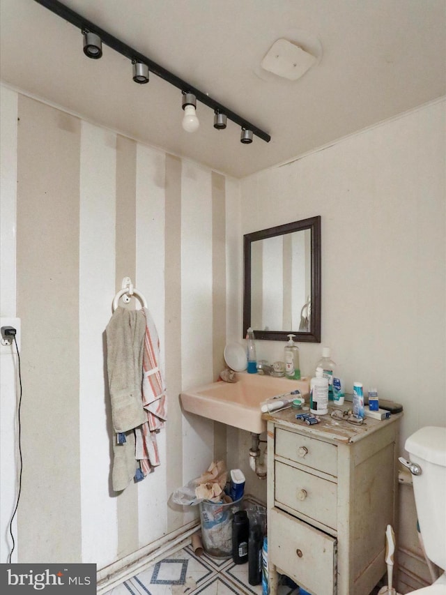 bathroom featuring toilet and rail lighting