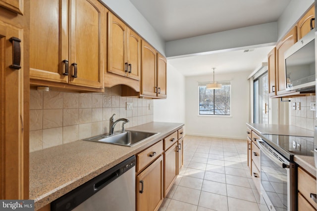 kitchen with hanging light fixtures, light tile patterned floors, tasteful backsplash, appliances with stainless steel finishes, and sink