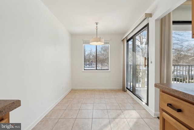 unfurnished dining area featuring light tile patterned floors