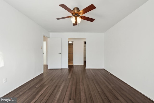 empty room with ceiling fan and dark wood-type flooring