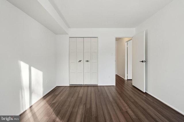 unfurnished bedroom featuring dark hardwood / wood-style flooring and a closet