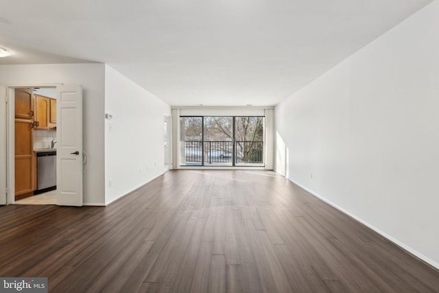 spare room with floor to ceiling windows and dark hardwood / wood-style floors