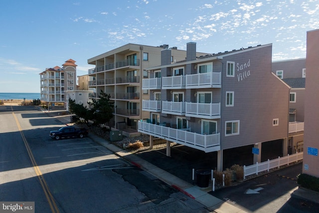 view of building exterior featuring central AC unit and a water view