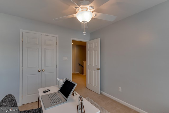 carpeted home office featuring ceiling fan