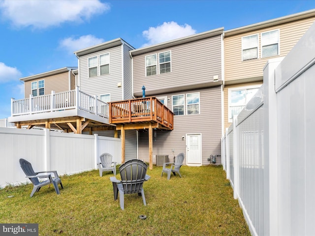 back of house with a deck, central AC unit, and a lawn