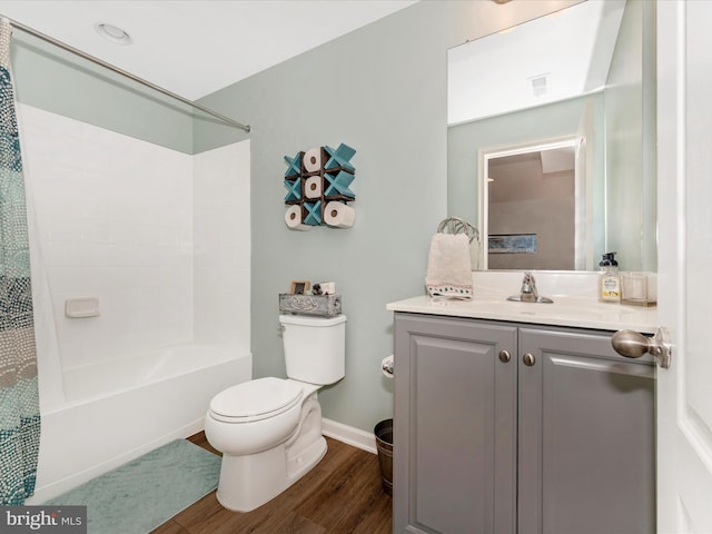 full bathroom with shower / bath combo with shower curtain, hardwood / wood-style floors, vanity, and toilet