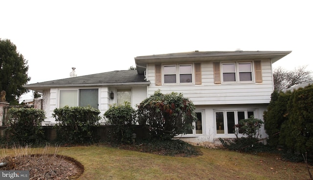 rear view of house featuring a yard