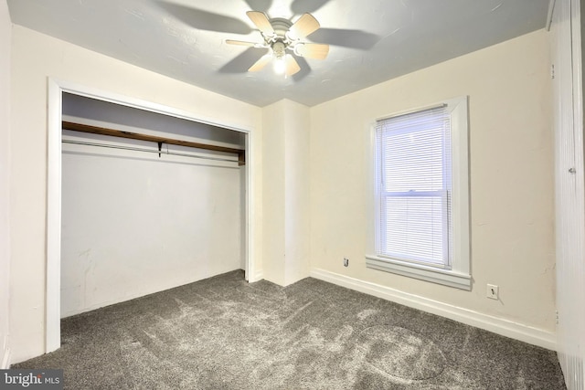 unfurnished bedroom featuring ceiling fan, a closet, and dark carpet