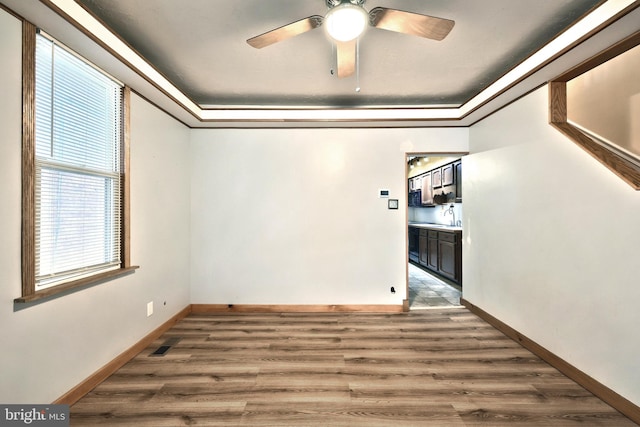 spare room with hardwood / wood-style floors, ceiling fan, ornamental molding, and sink