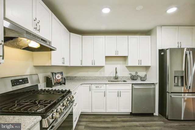 kitchen featuring dark hardwood / wood-style floors, sink, light stone countertops, stainless steel appliances, and white cabinets