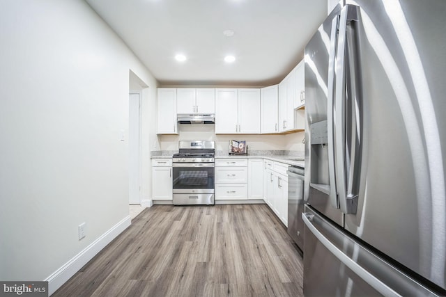 kitchen with white cabinets, light wood-type flooring, and appliances with stainless steel finishes