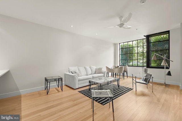 living room with light hardwood / wood-style flooring and ceiling fan