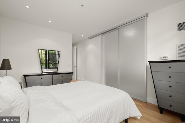 bedroom with light wood-type flooring and a closet