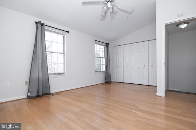 unfurnished bedroom with ceiling fan, light wood-type flooring, lofted ceiling, and a closet