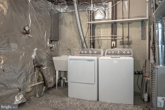 washroom featuring washing machine and dryer, electric panel, and sink