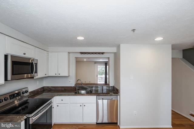 kitchen featuring white cabinetry, sink, appliances with stainless steel finishes, and light hardwood / wood-style flooring