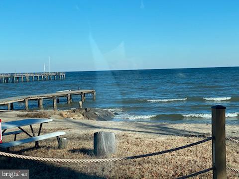 view of dock with a water view and a view of the beach