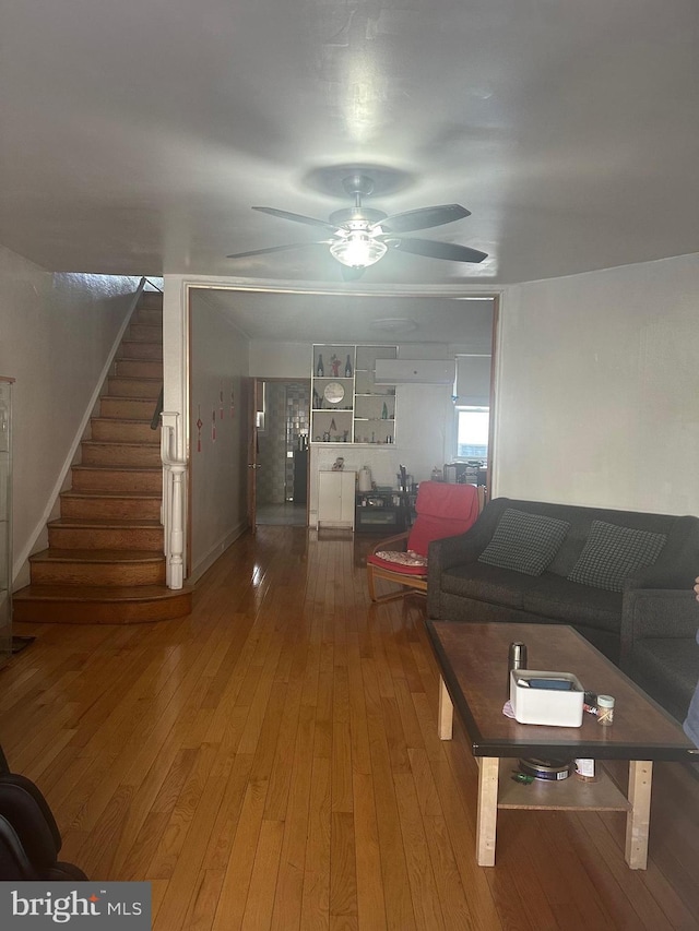 living room with wood-type flooring and ceiling fan