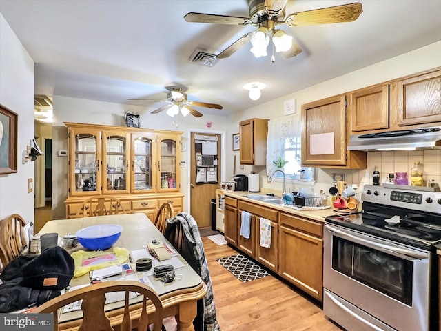 kitchen with ceiling fan, sink, tasteful backsplash, light hardwood / wood-style floors, and stainless steel range with electric stovetop