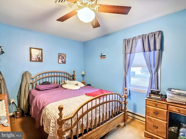 carpeted bedroom with ceiling fan and a baseboard heating unit