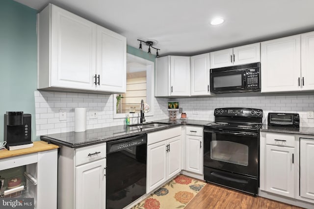 kitchen with backsplash, sink, black appliances, wood-type flooring, and white cabinetry